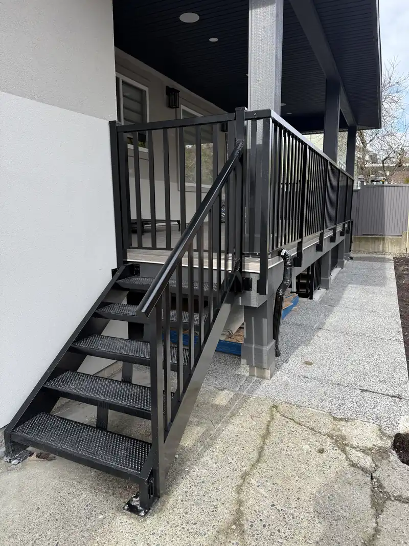 Aluminum stair with black treads and wide-picket railing