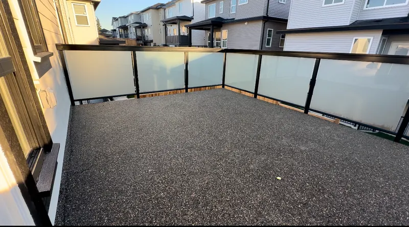 Frosted glass railing in a black aluminum frame around a balcony
