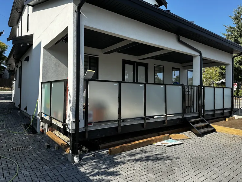 Frosted glass railing around a covered porch with aluminum steps