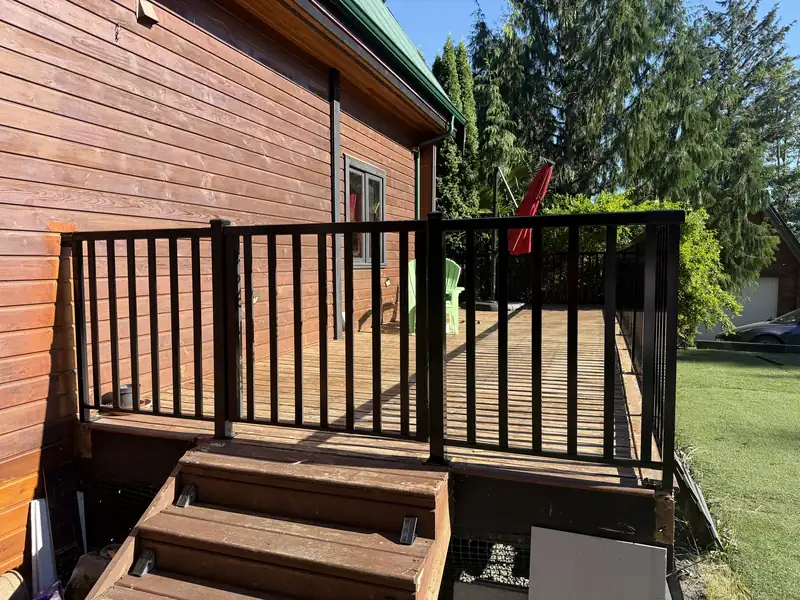 Wide-picket aluminum railing and gate on a cedar deck