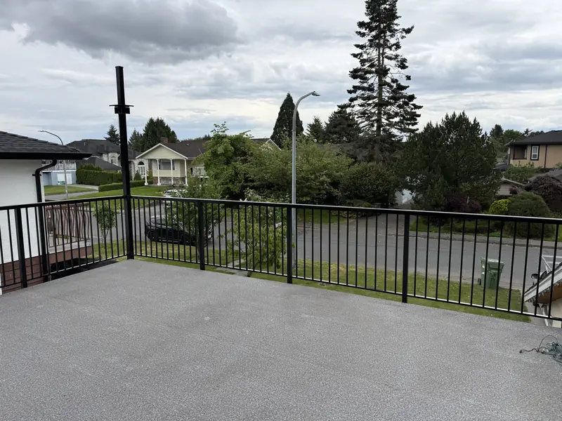 Black picket railing around a resurfaced front patio