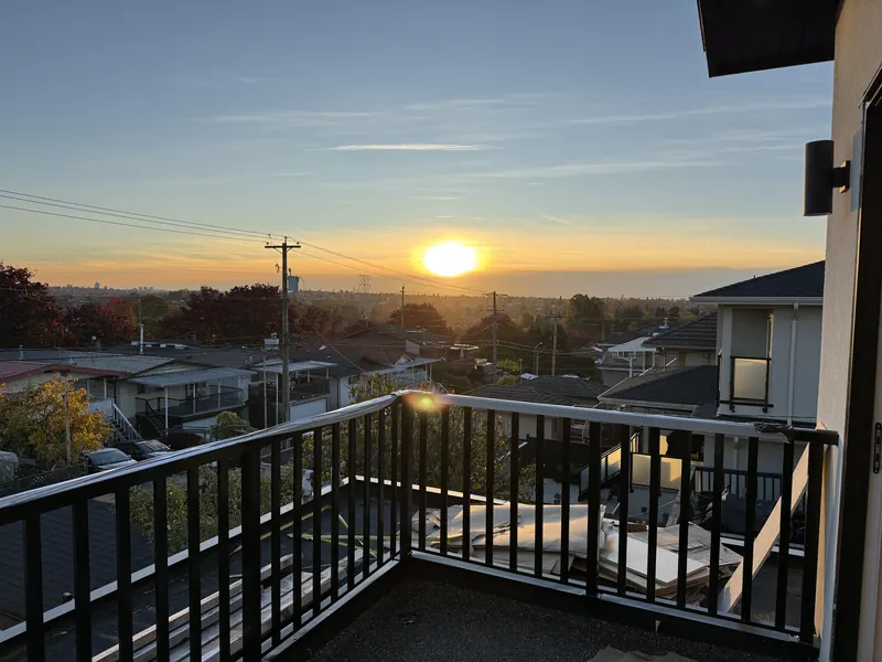 Black picket railing on a rooftop deck at sunset