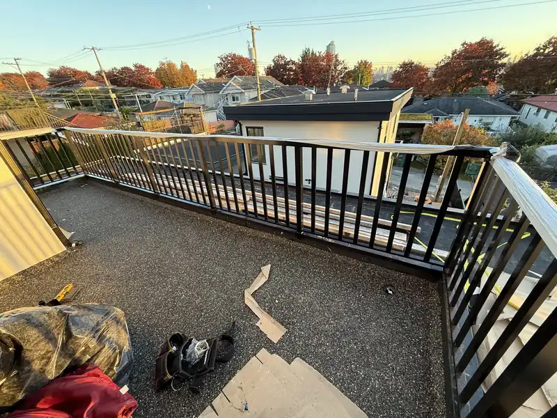 Picket railing around a rooftop deck at sunset