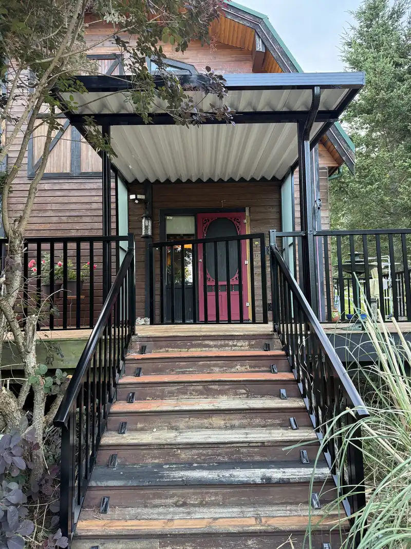 Picket stair railing leading up to a covered front entry