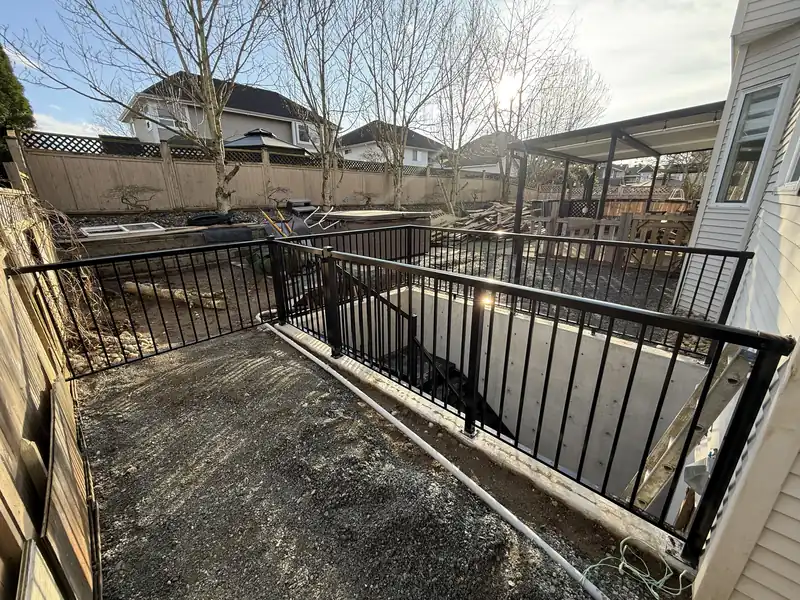 Picket railing stepping down along a backyard retaining wall